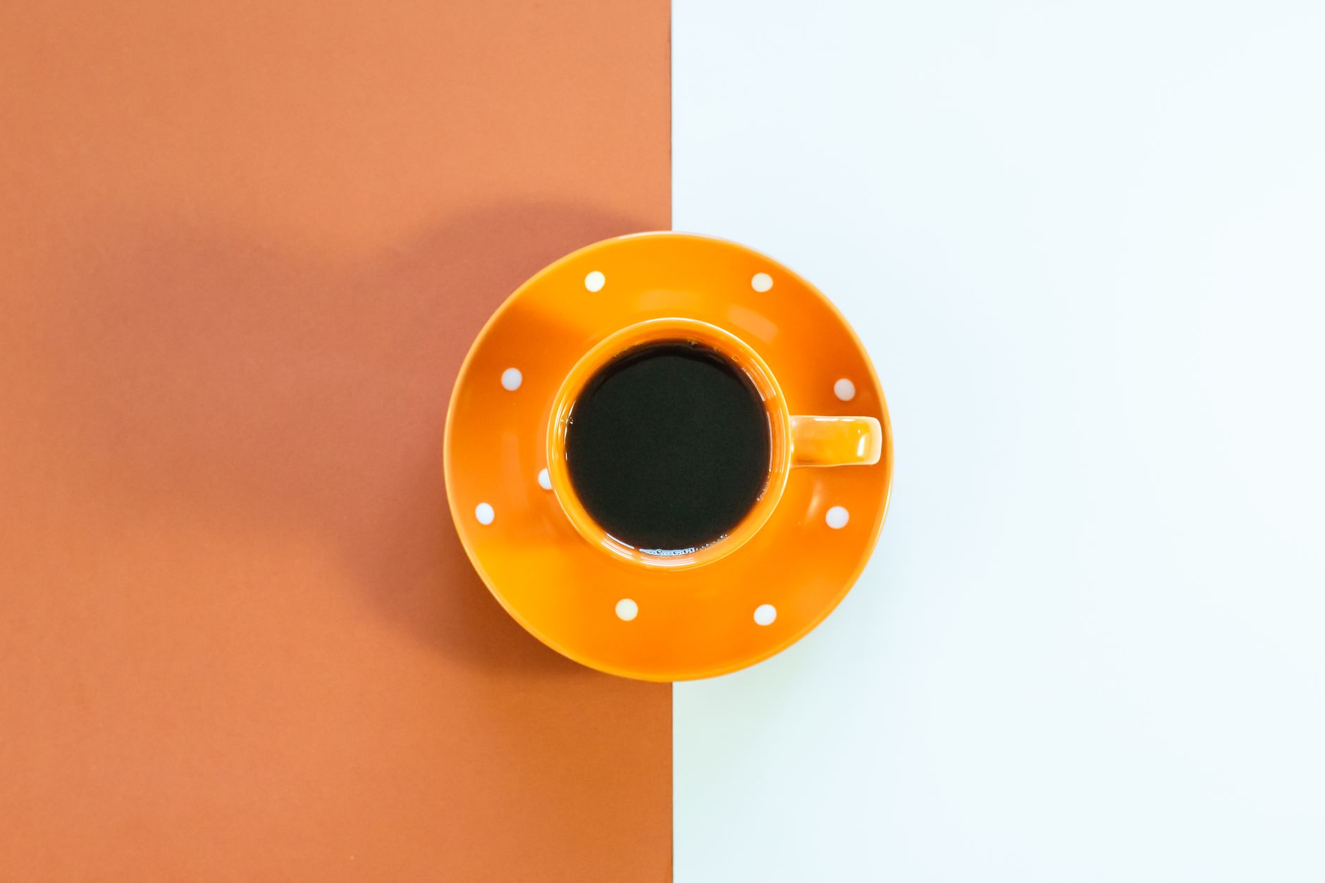 bright orange cup on minimalist background